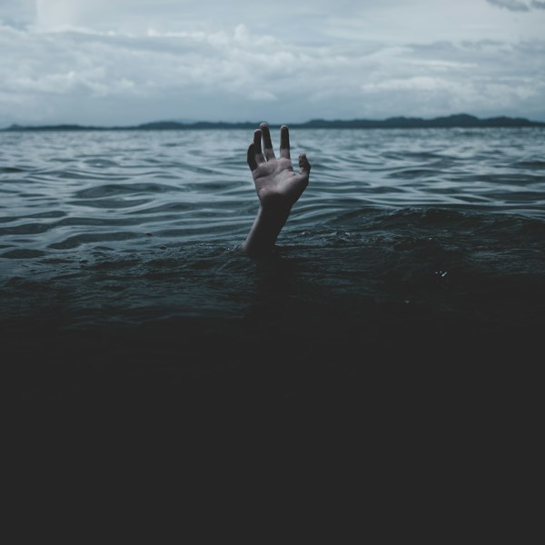 A hand reaching up out of dark water